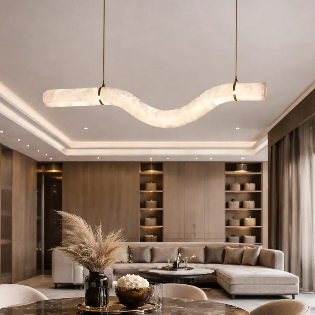 W-Curve alabaster pendant light glowing above a sectional sofa in a modern living room