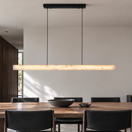 Illuminated Nevella linear LED pendant above a dark wood dining table