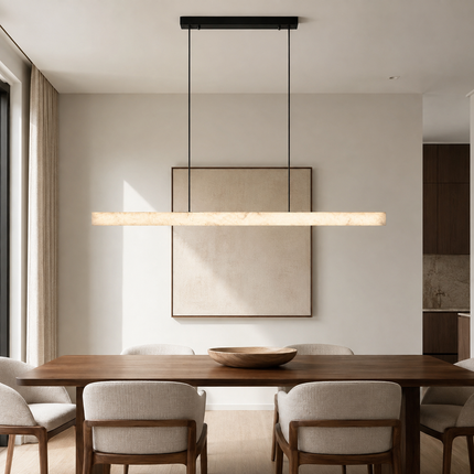 Nevella alabaster pendant light above a walnut dining table in a warm neutral room