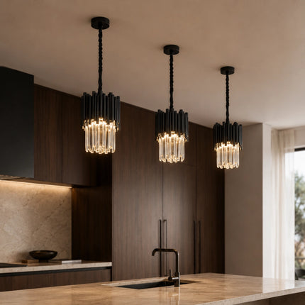 Three Arcelle black metal crystal pendant lights above a kitchen island with warm lighting